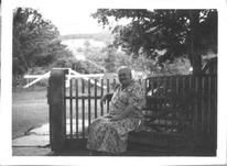 SA1708.44 - Lillian is sitting on a bench out of doors., Winterthur Shaker Photograph and Post Card Collection 1851 to 1921c